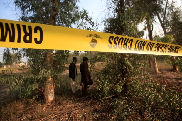 Men walk near a cordoned area after remains were found in the lions' enclosure at a safari park in Lahore