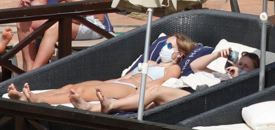  Guests at the H10 Costa Adeje Palace who have been told to self-isolate in their rooms after an Italian couple were diagnosed with the bug are pictured lounging by the pool