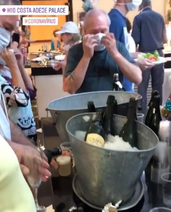  Holidaymakers enjoy champagne at the buffet where the hotel is still serving food to people - despite two guests testing positive for the bug