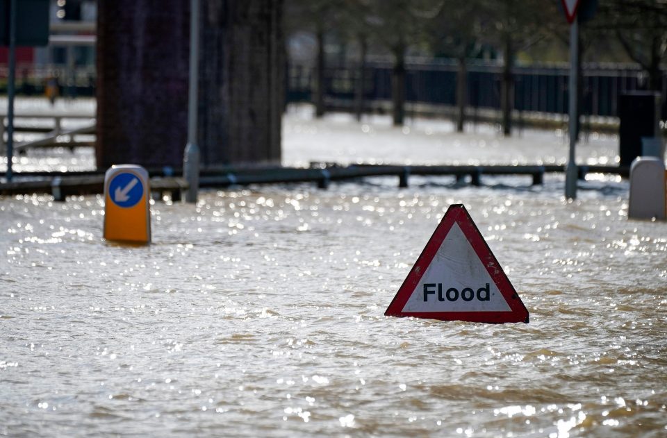  A warning sign is surrounded by water amid the extreme weather