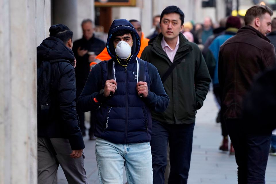  A pedestrian is seen wearing a surgical face mask on Regents Street in central London