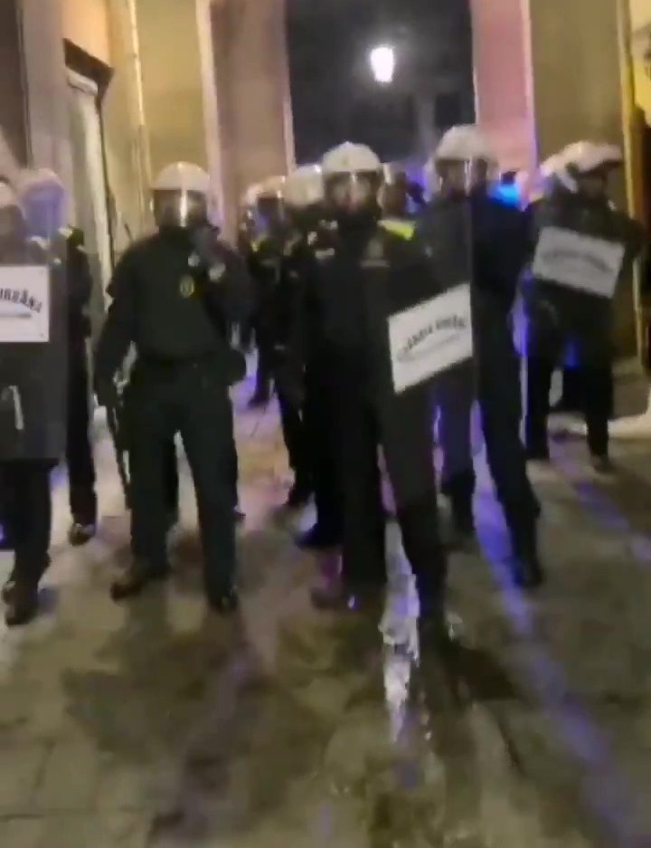  Riot cops with raised shields lined up against Wolves fans in an arcade