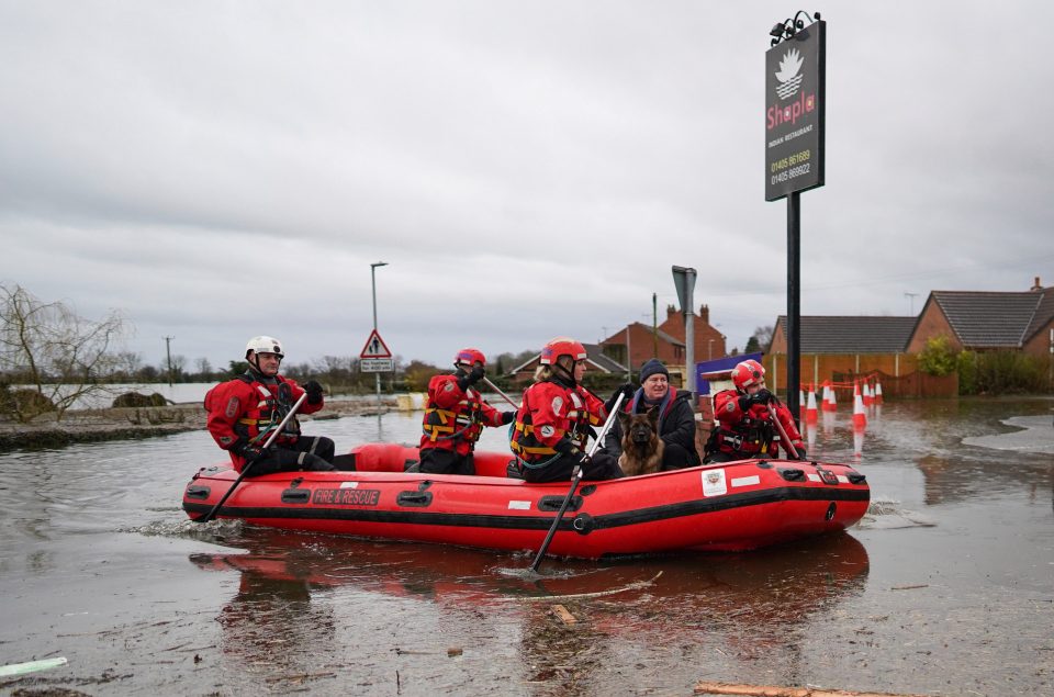  Humberside Fire and Rescue crews search along a flooded street for residents who need to evacuate