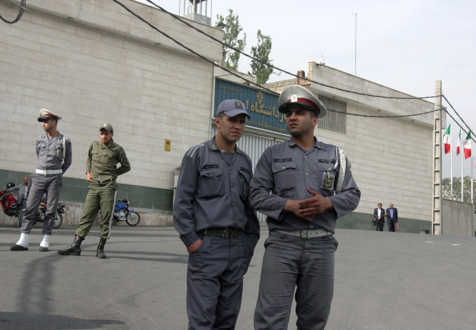  Iranian police officers stand guard outside of the main entrance to Evin prison in north of Tehran