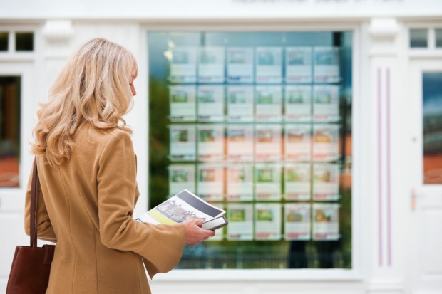 Woman looking at estate agent window