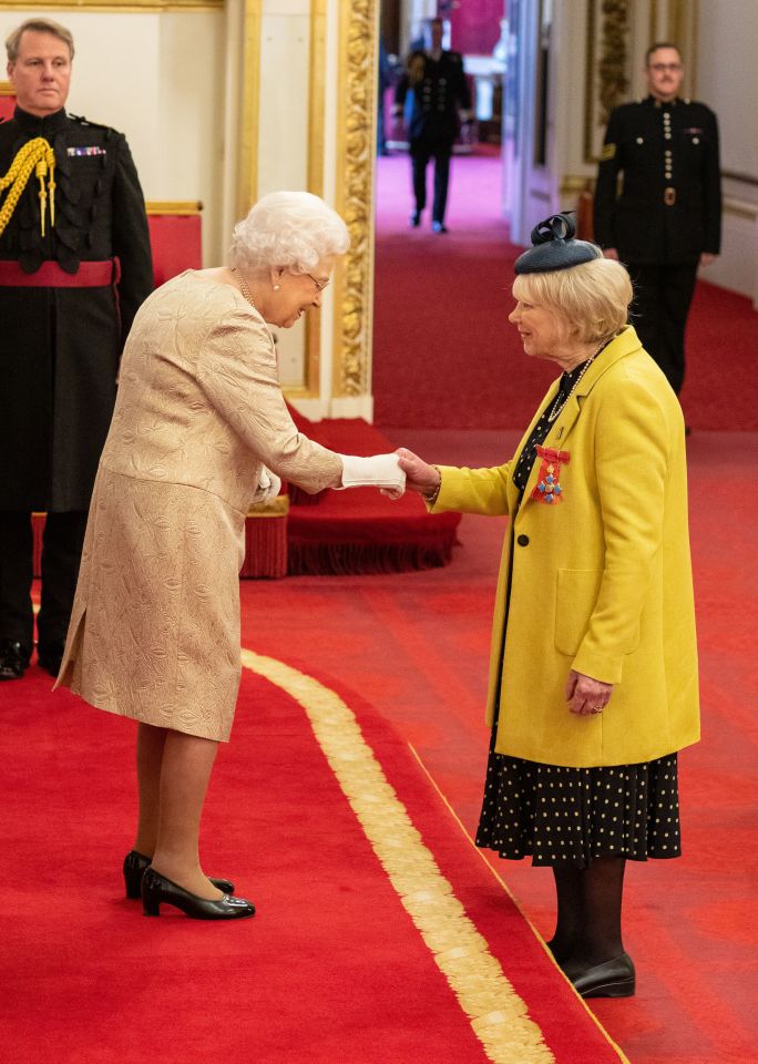  The Queen wore gloves for the Buckingham Palace ceremony - pictured shaking hands with actress Wendy Craig