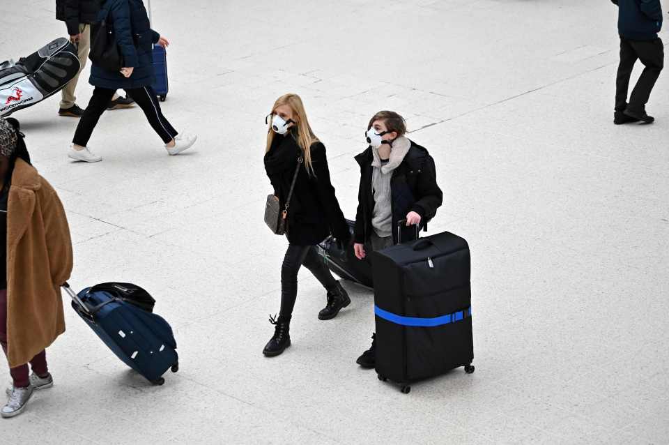  Travellers wearing face masks at London Victoria train station in central London