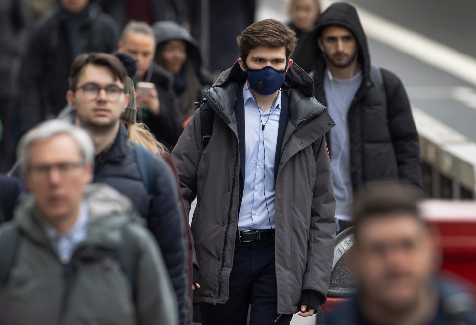  A commuter wears a face mask as he crosses London Bridge