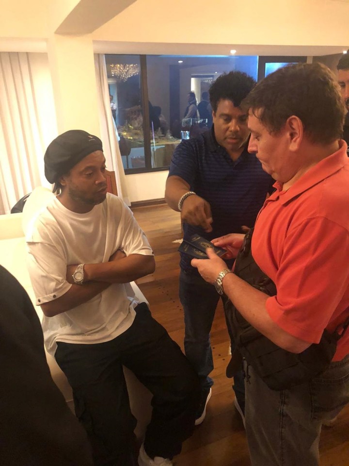  Ronaldinho, left, being quizzed by cops in his hotel over the suspect passports