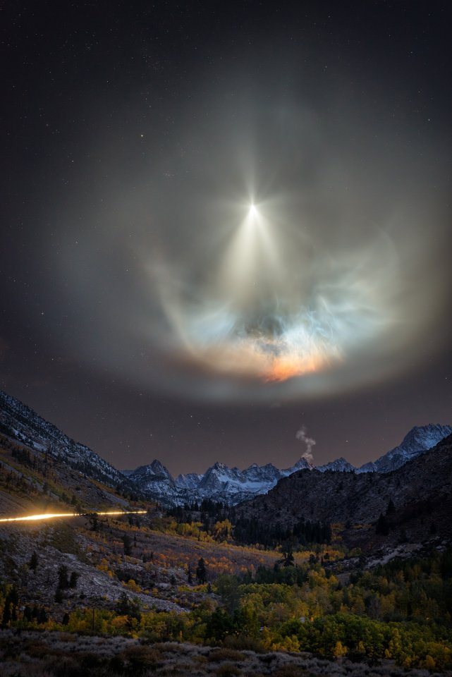 The setting sun highlights the exhaust plume from a SpaceX rocket launch over Aspendell, California