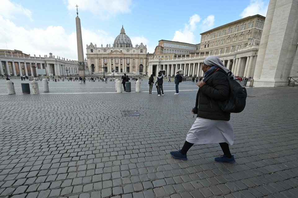 A nun walks on a deserted St. Peter’s square at the Vatican on March 6