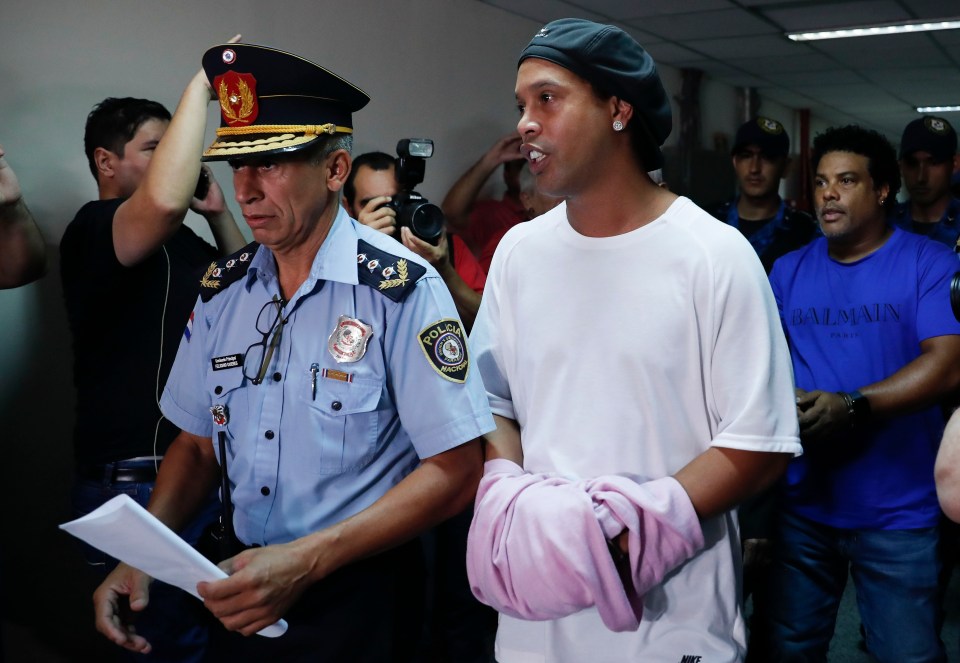  Ronaldinho's hands were cuffed but covered in a pink jumper as he was taken before a judge