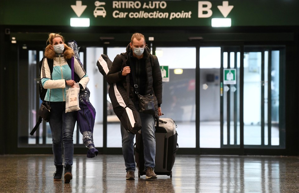  People wearing protective masks walk in Malpensa airport near Milan