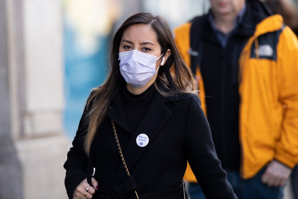  A woman wears a face mask as she walks along Oxford Street in London