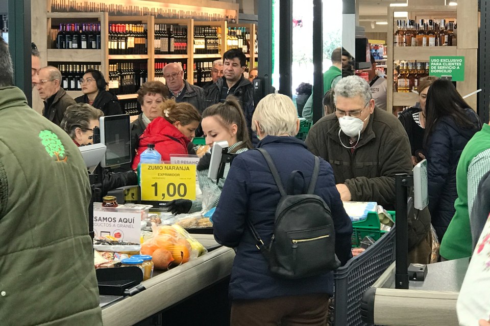  Shoppers wearing masks while buying supplies as the number of coronavirus cases triple in two days