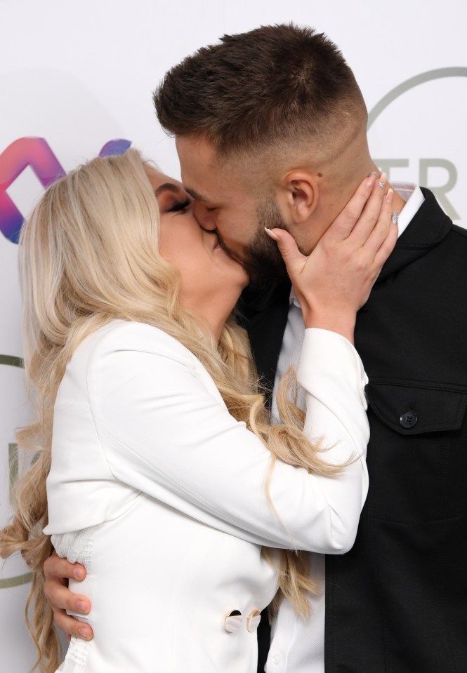 The couple shared a smooch on the carpet