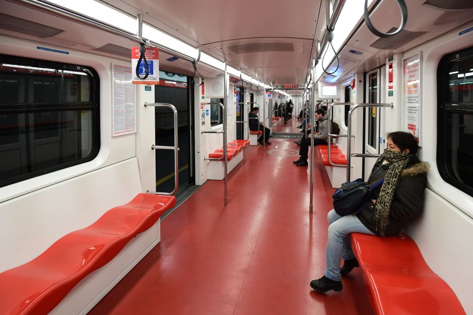  Commuters in Milan sit far apart from each other while travelling on the metro