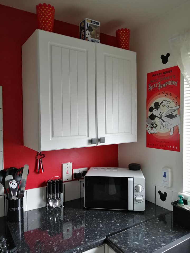  The kitchen was made up of white cabinets with black bench tops and featured an eye-popping lava red wall