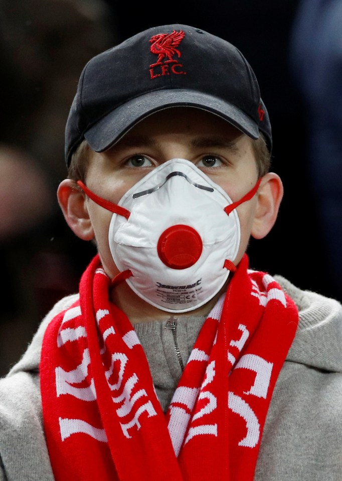  A Liverpool fan wearing a face mask watches last night's match at Anfield