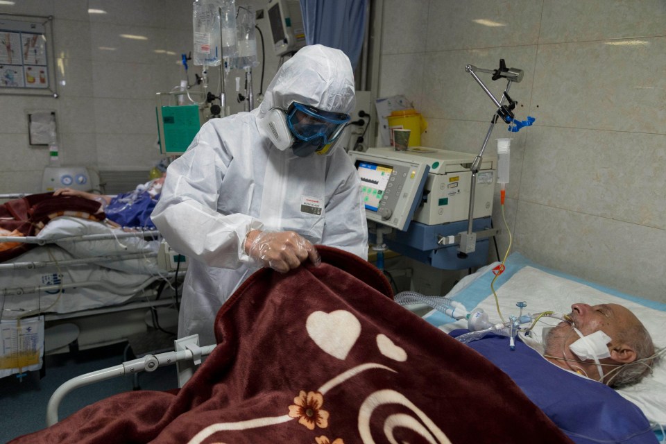 A medic in a hazmat suit treats a coronavirus patient in Tehran, Iran