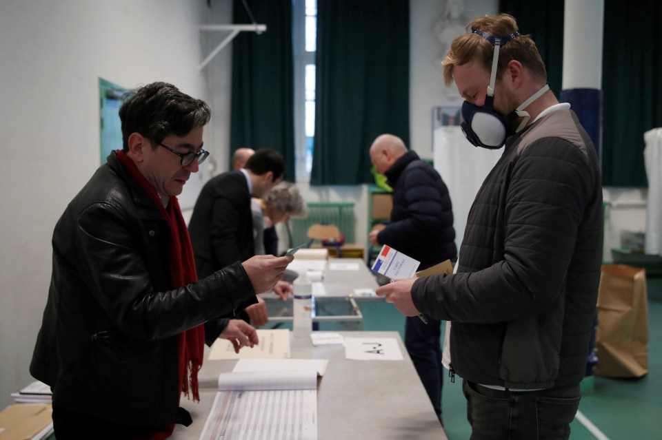  A man wears a mask while casting his vote in the local election in Paris over the weekend