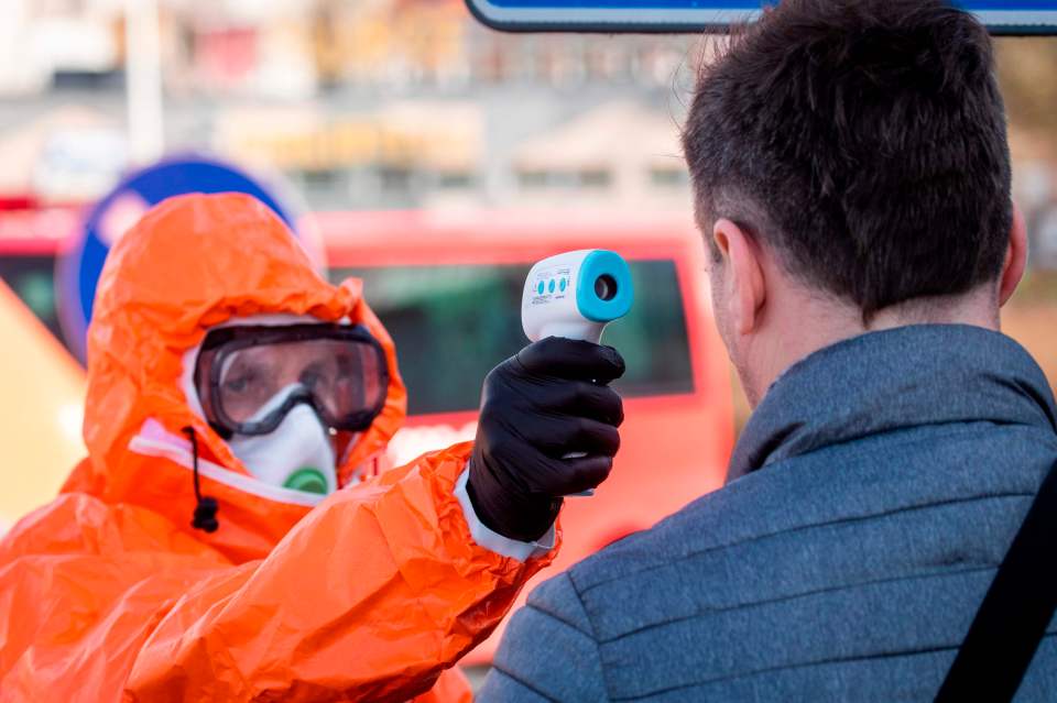  A Polish health official checks the temperature of people crossing from Germany