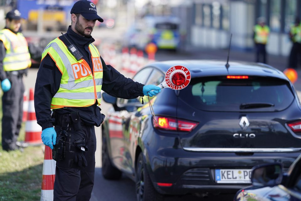  A German cop stops cars at the border crossing to France yesterday