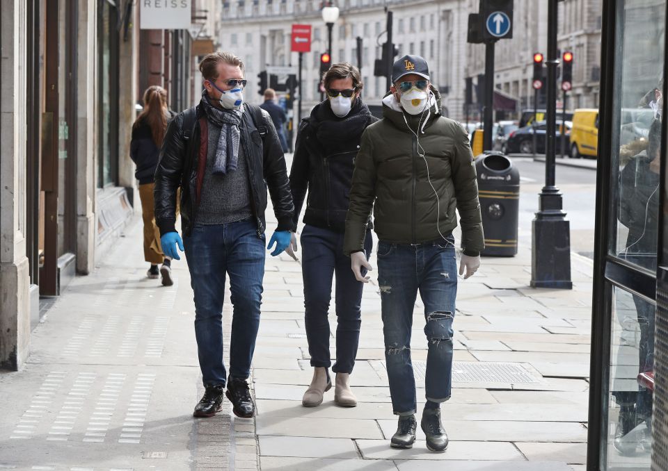  Three men wear face masks as they walk down Regent Street today