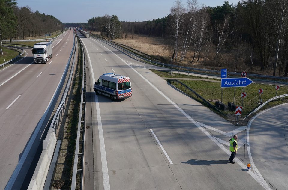  A cop diverts cars from a line of trucks stretching over 40km