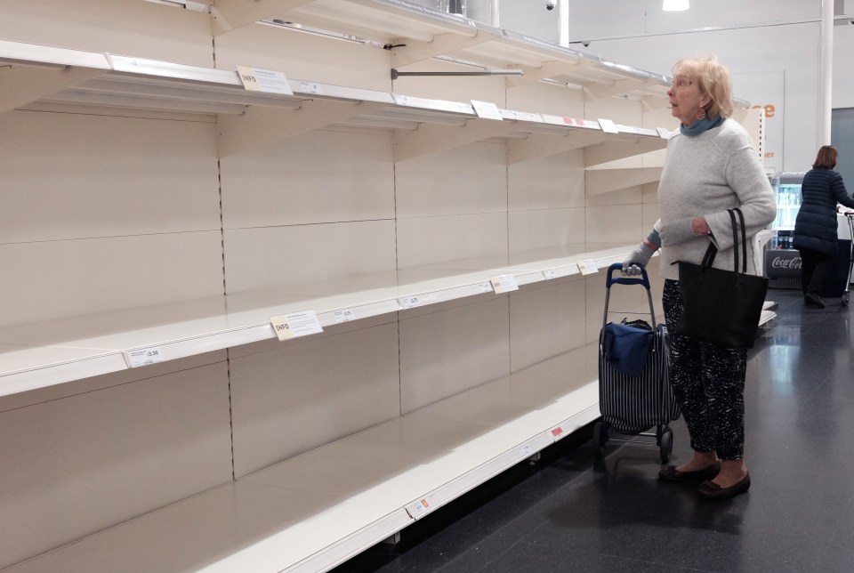 A lady looking at empty shelves in a Sainsbury’s store in London on Wednesday morning