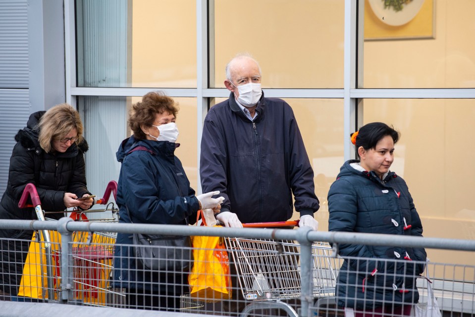 A line of shoppers wear face masks as coronavirus cases continue to rise