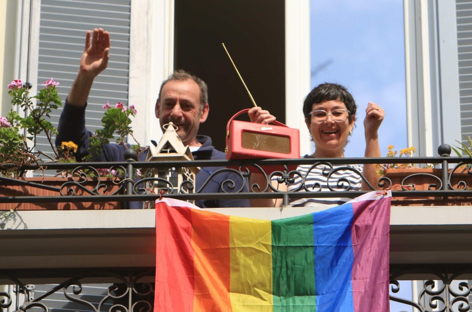  A Spanish couple under quarantine wave from their balcony