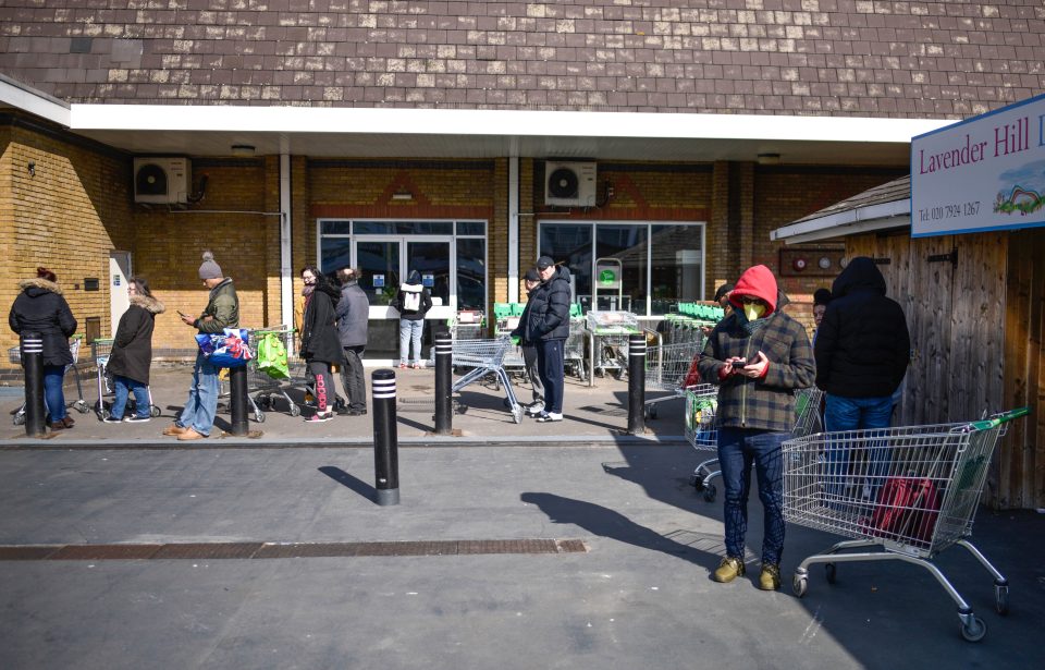  A man in a facemask waits for the supermarket to open its doors