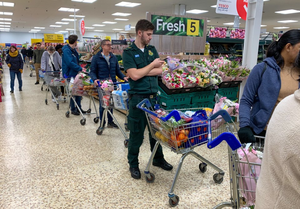  A man in a paramedic uniform can be seen with a trolley full of food