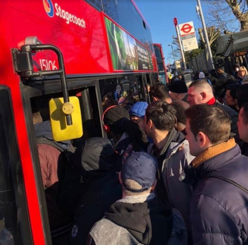  Commuters pile onto a bus this morning