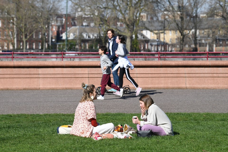 Two women sit in a park this week amid the coronavirus crisis