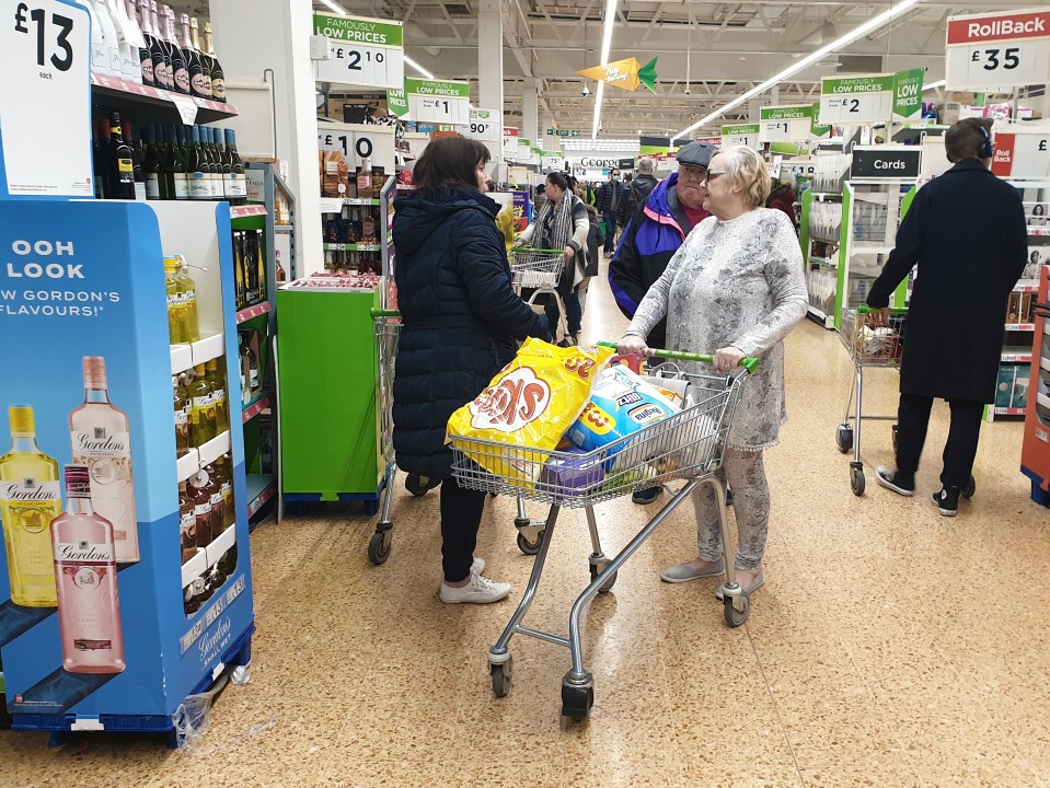  Shoppers squeeze their trollies past one another in an East London Asda