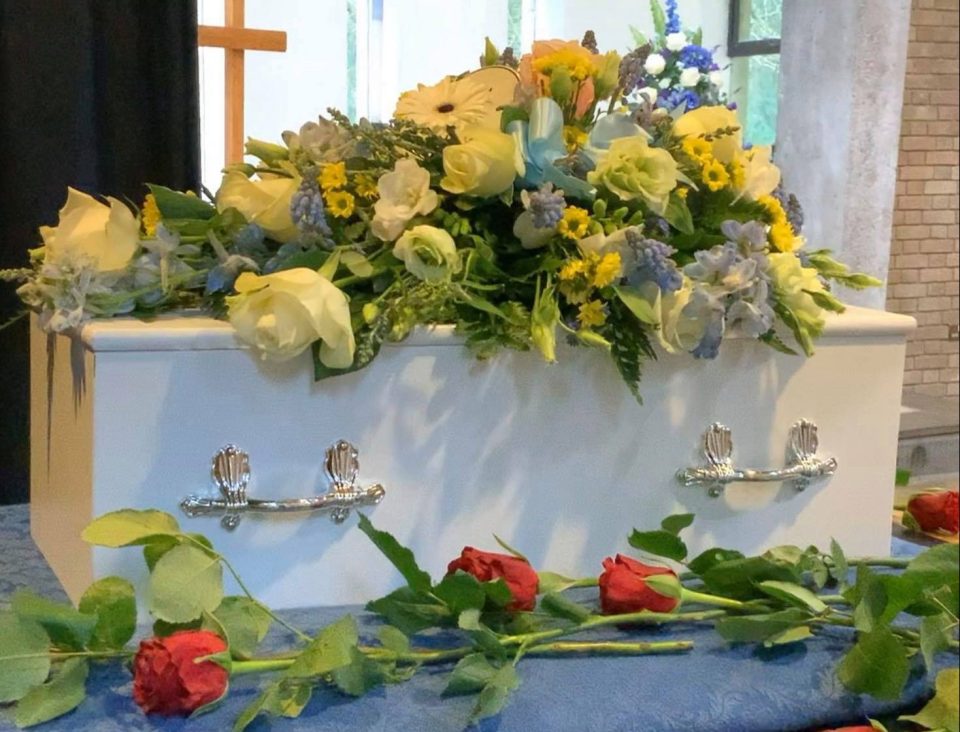  A beautiful bouquet of flowers sits atop Samuel's tiny coffin