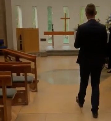  Jordan walks past empty crematorium pews, cradling Samuel's tiny coffin