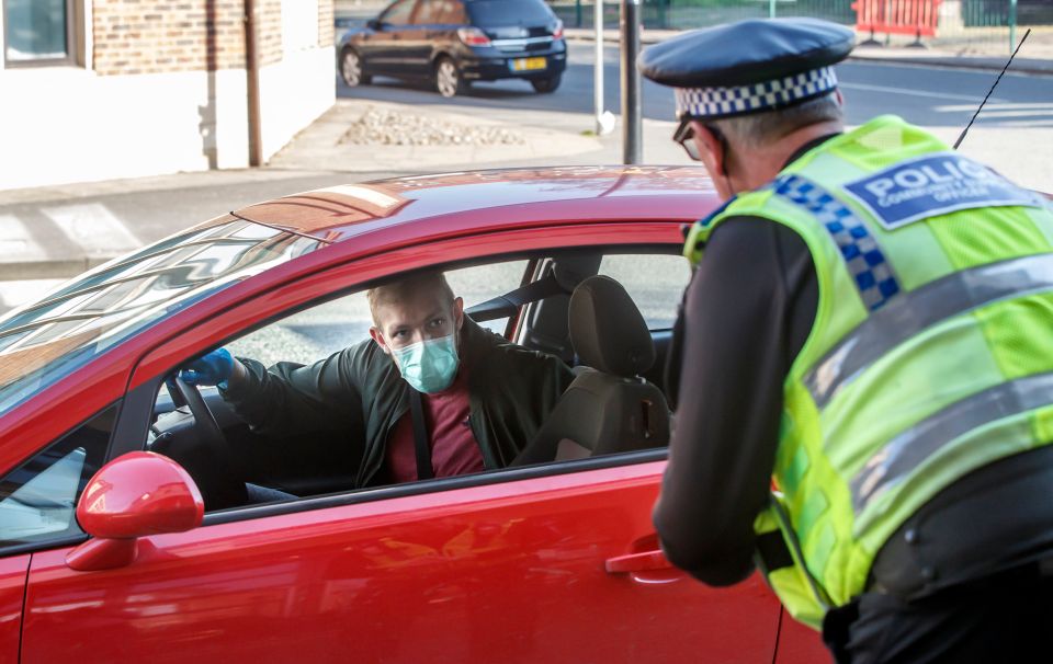  Police speak to a driver in a facemask in York as officers reinforce the stay at home message