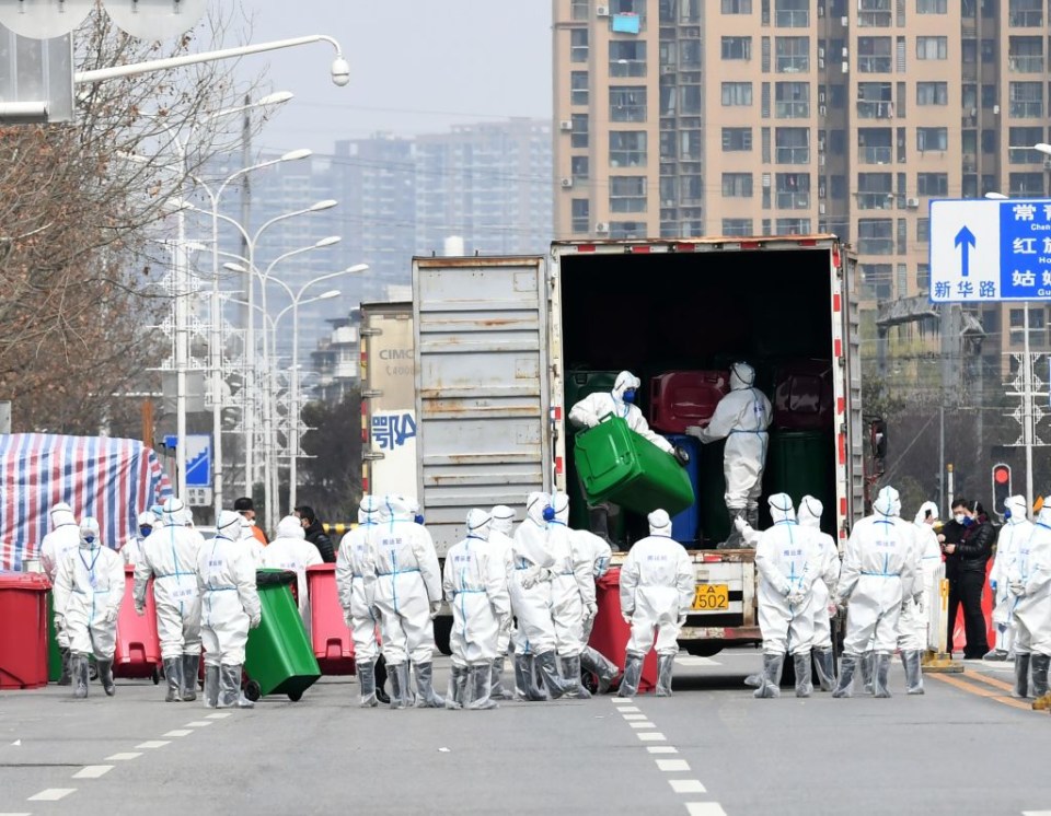 Officials wearing protective suits carry out disinfection work at Hua’nan Wholesale Seafood Market in Wuhan