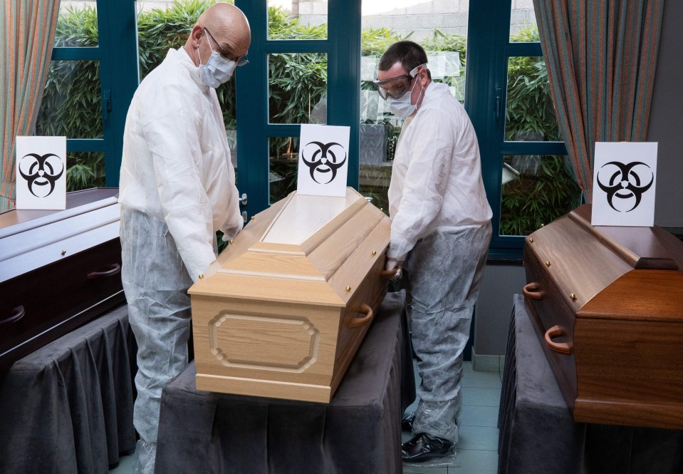 Belgian medical workers carry the coffins of coronavirus victims last week