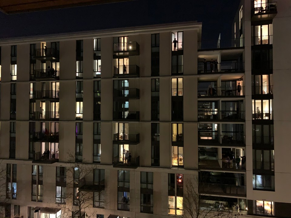 A tower block in East London is lit up with applause