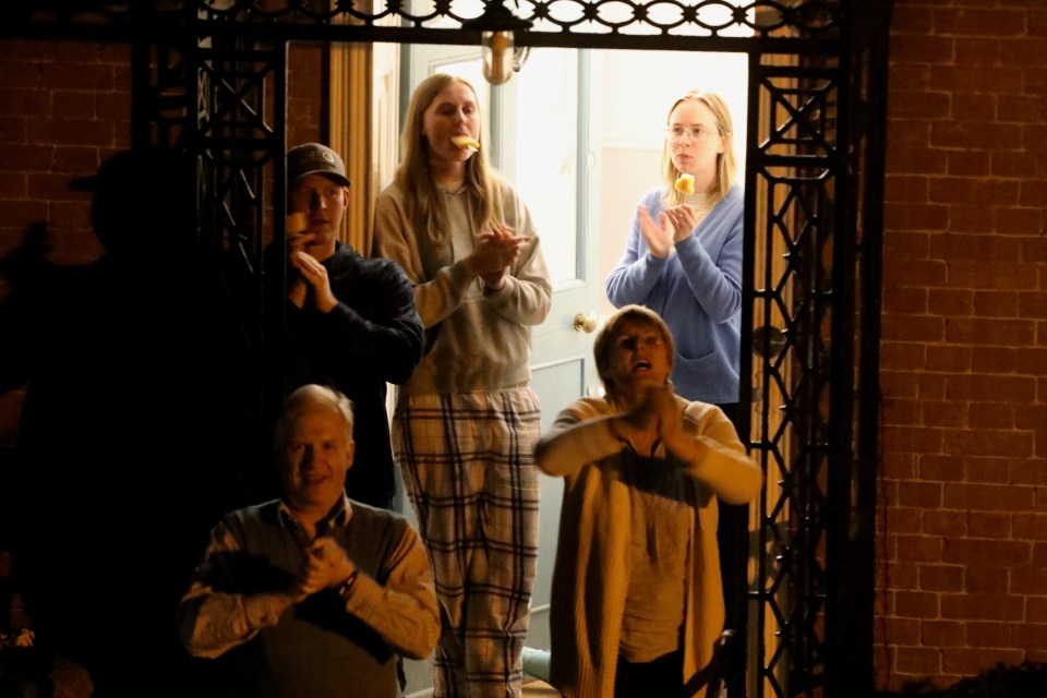 A family stand on their doorstep to join with the mass clapping