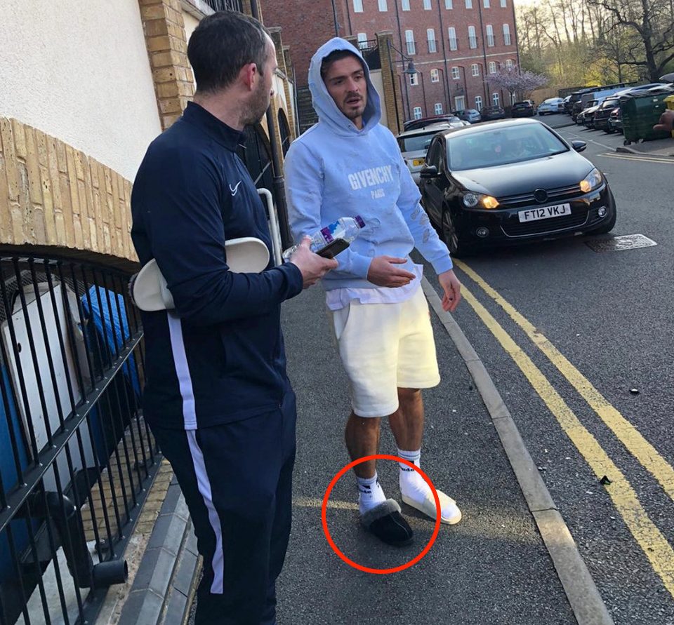  Jack Grealish was seen talking to onlookers while wearing one black slipper and a white slip-on sandal