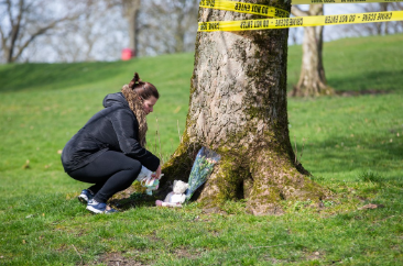  A woman leaves floral tributes to the tragic youngster near the scene