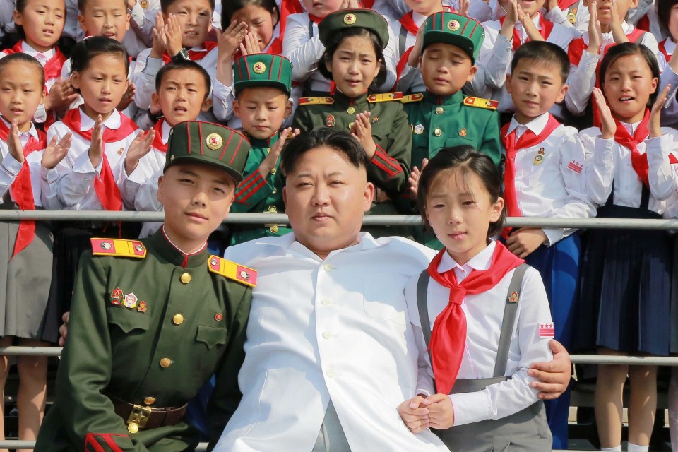  It is not clear how many children Kim, pictured with North Korean schoolchildren, has of his own