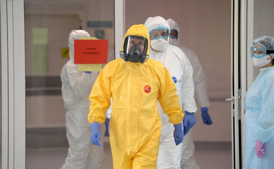 Vladimir Putin wearing a yellow personal protective suit on a visit to a Moscow hospital on March 24