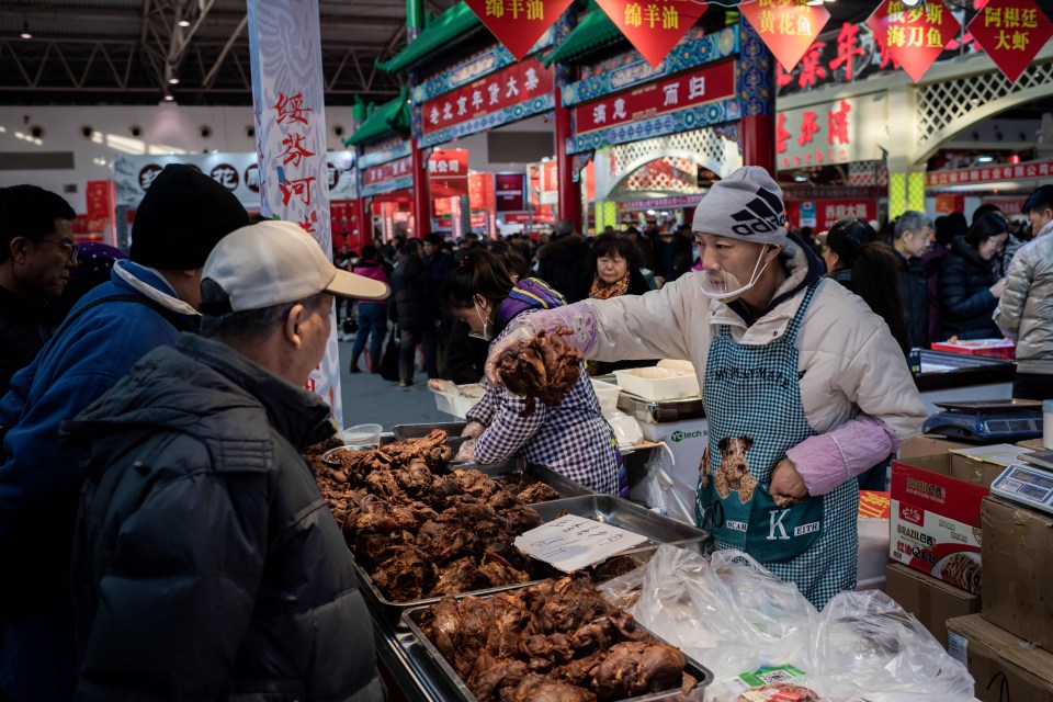 Workers wearing facemasks operate a barbecue at a market in Wuhan in China’s central Hubei province