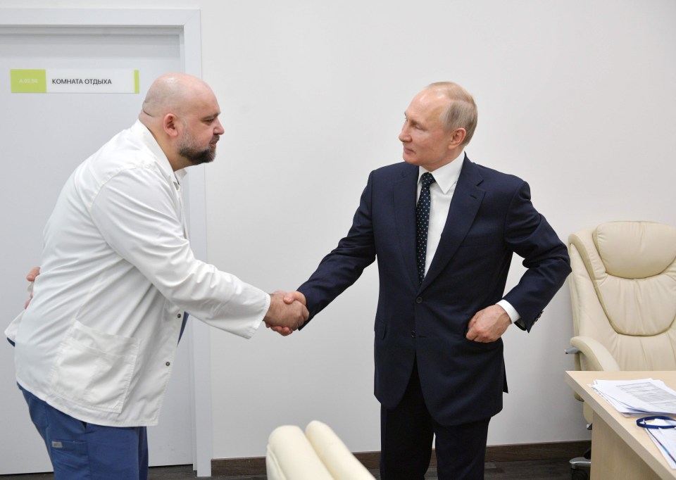 Vladimir Putin shaking hands with the head of Moscow’s main coronavirus hospital Denis Protsenko on March 24